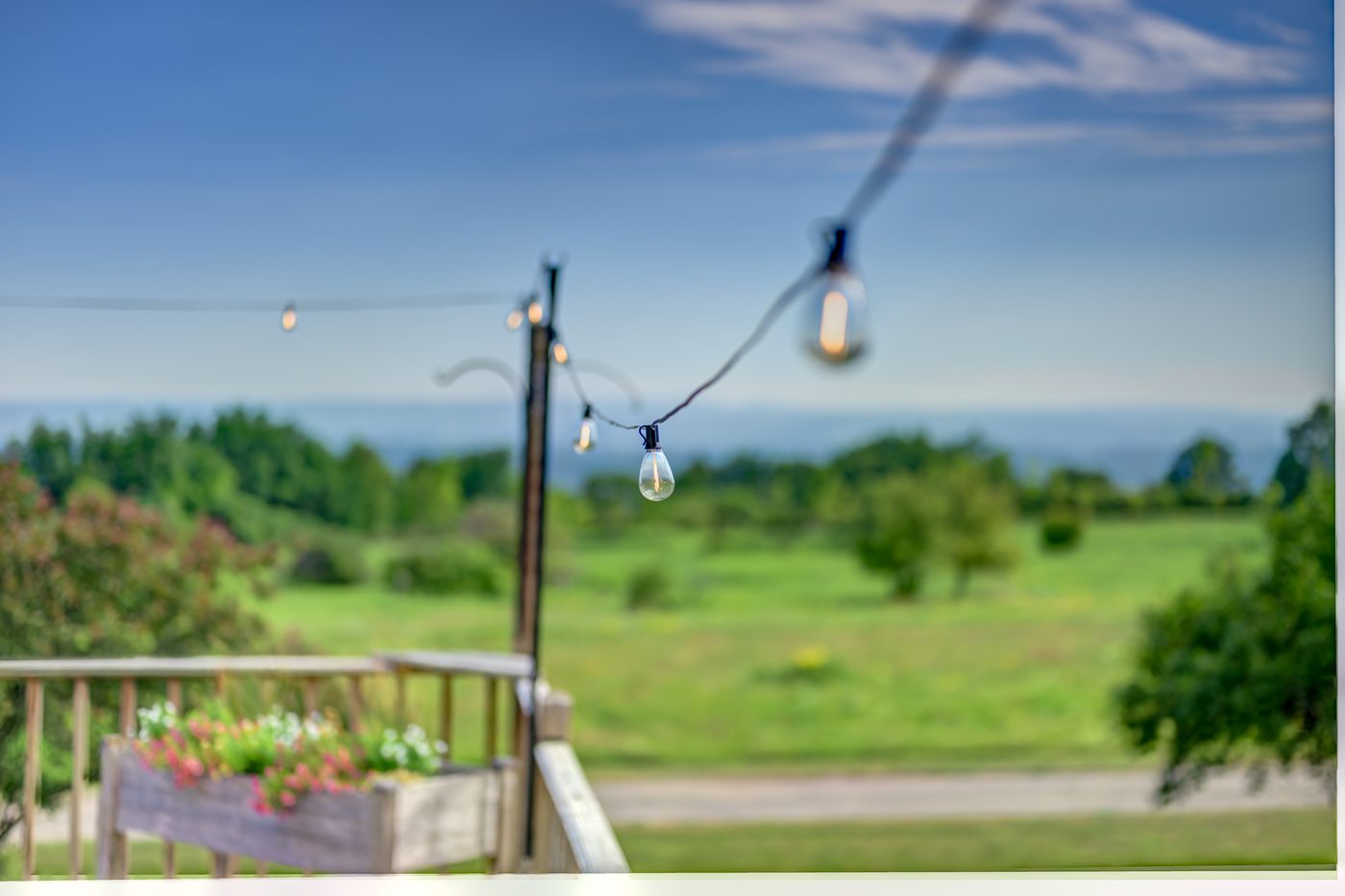 String lights strung across the deck above the valley at dusk
