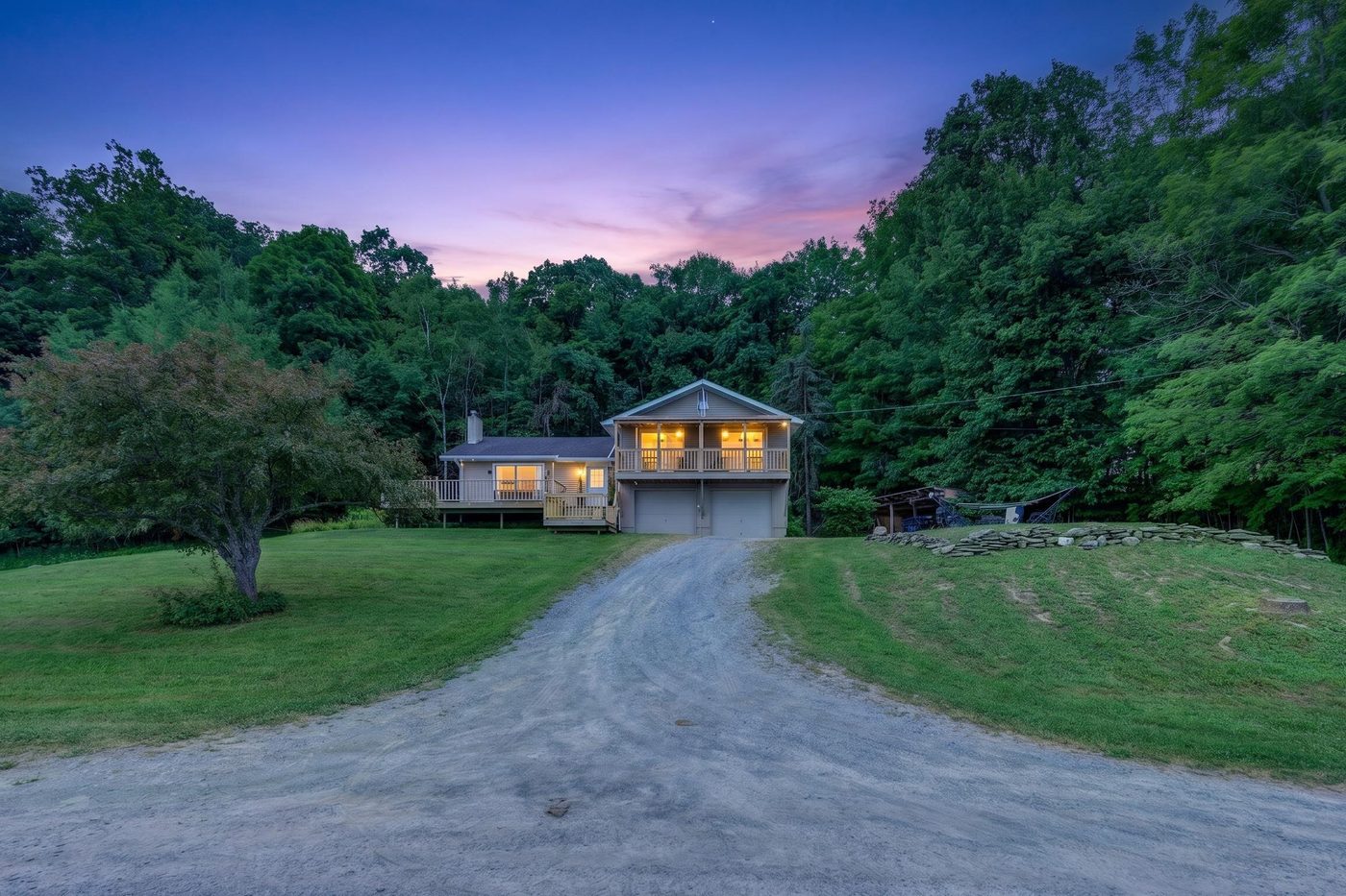 The driveway at dusk with the house lit
