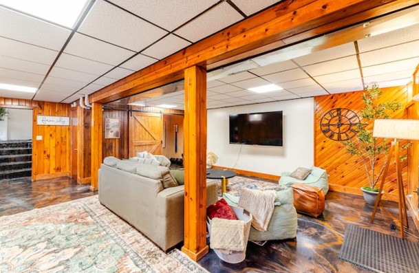 Finished basement with pine walls, sectional and large television
