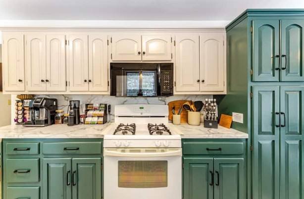 Kitchen with green cabinets and marble counters