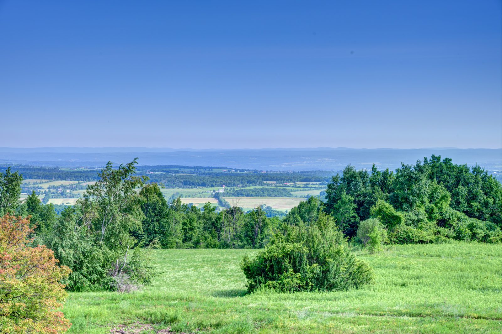 View north from the property across green fields to the hazy valley and distant ridges